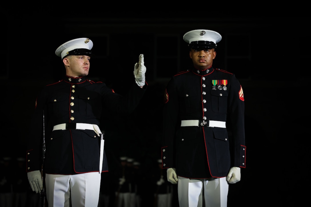 U.S. Marine Corps Cpl. Cameron Holmes, rifle inspector, and Lance Cpl. Eric Jones, rifleman, left, both with the United States Marine Corps Silent Drill Platoon, conduct a drill sequence during a Friday Evening Parade at Marine Barracks Washington, D.C., Aug. 15, 2025. Gen. Christopher J. Mahoney, Assistant Commandant of the Marine Corps, hosted the evening's parade in honor of the Deputy Secretary of Defense, Steve Feinberg. The Evening Parade highlights the Marine Corps’ precision, discipline, and heritage before guests from across the National Capital Region. (U.S. Marine Corps photo by Lance Cpl. Brynn L. Bouchard)