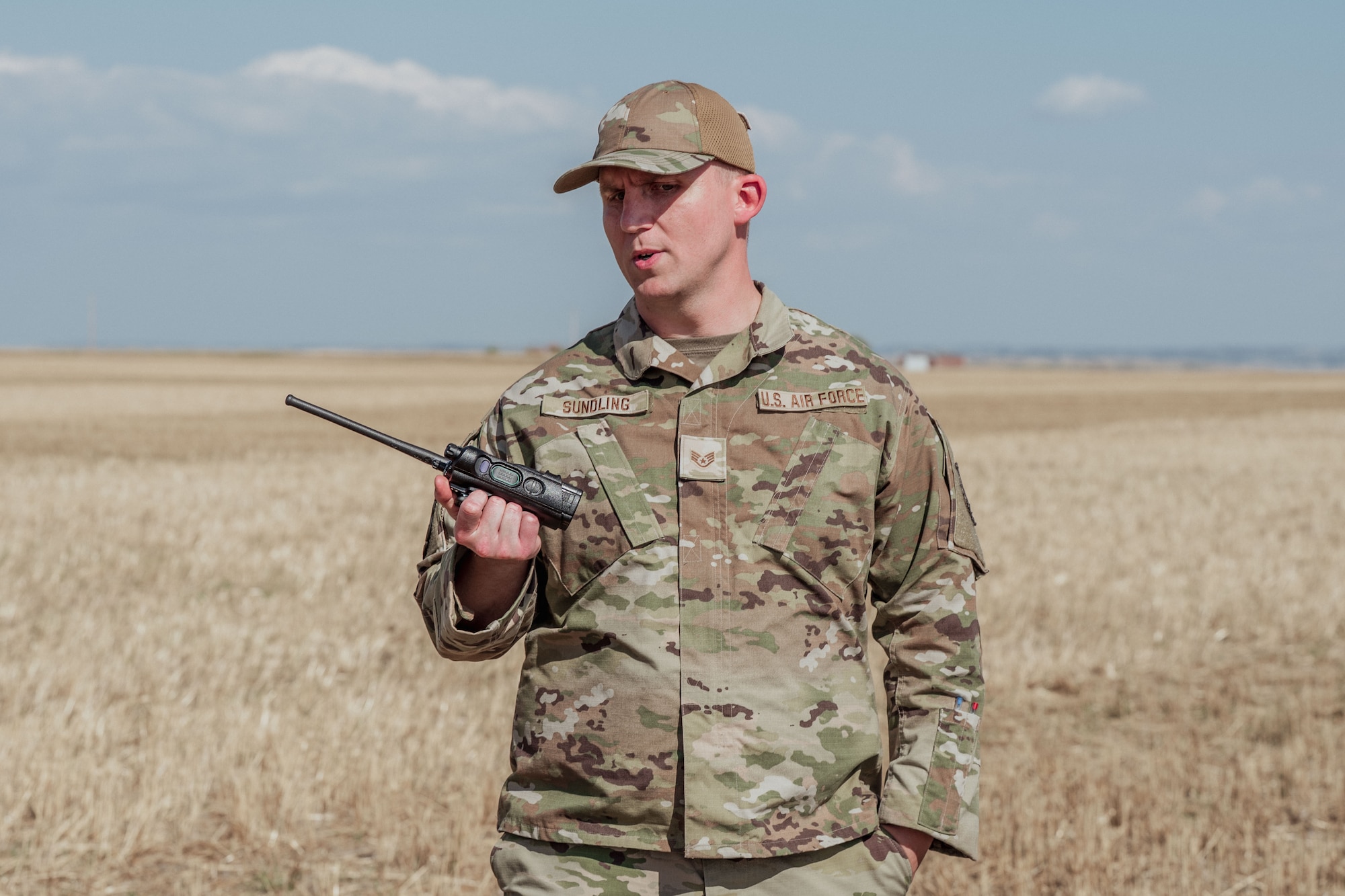 An Airman listening to a two-way radio.