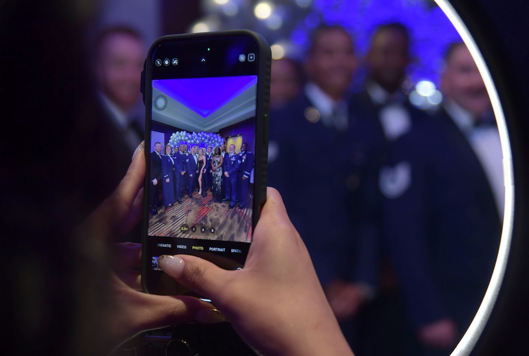 A cell phone displays a group photo as a photo is being taken.