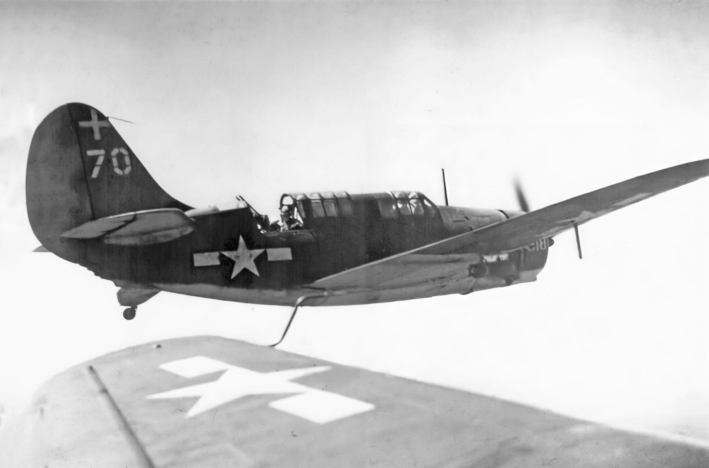 Taking over from the veteran Douglas SBD Dauntless, the Curtiss SB2C Helldiver became the primary carrier-based dive bomber. Here, a Helldiver from VB-18 is enroute against the Japanese fleet in October 1944. Navy photographer Richard Shipman took this photo from the backseat of another SB2C.