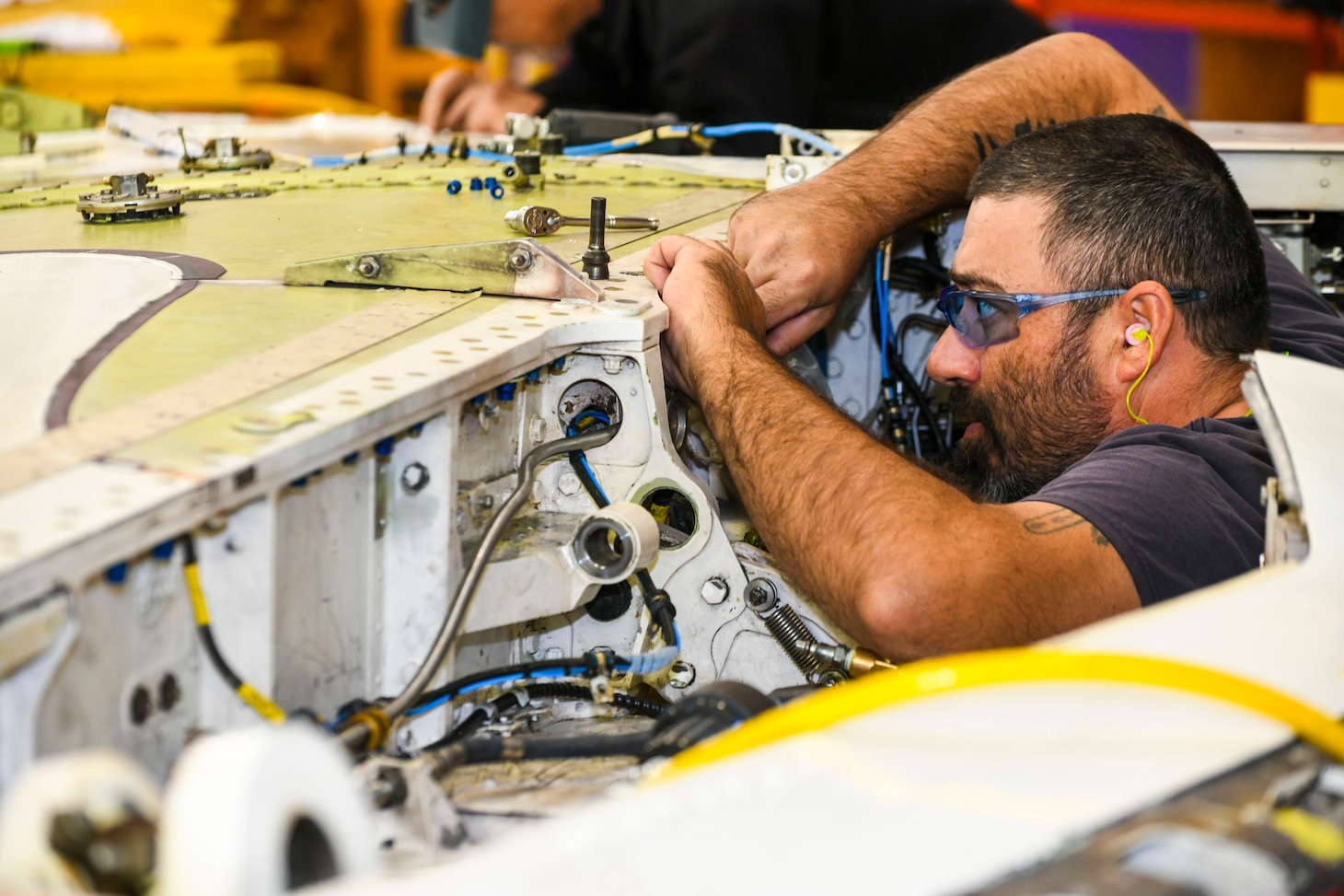 Kristopher Williams, a sheet metal mechanic at Fleet Readiness Center Southeast (FRCSE), performs an accessory change on a T-45 Goshawk forward wing spar. The T-45 jet aircraft is used for intermediate and advanced portions of the Navy/Marine Corps pilot training program.