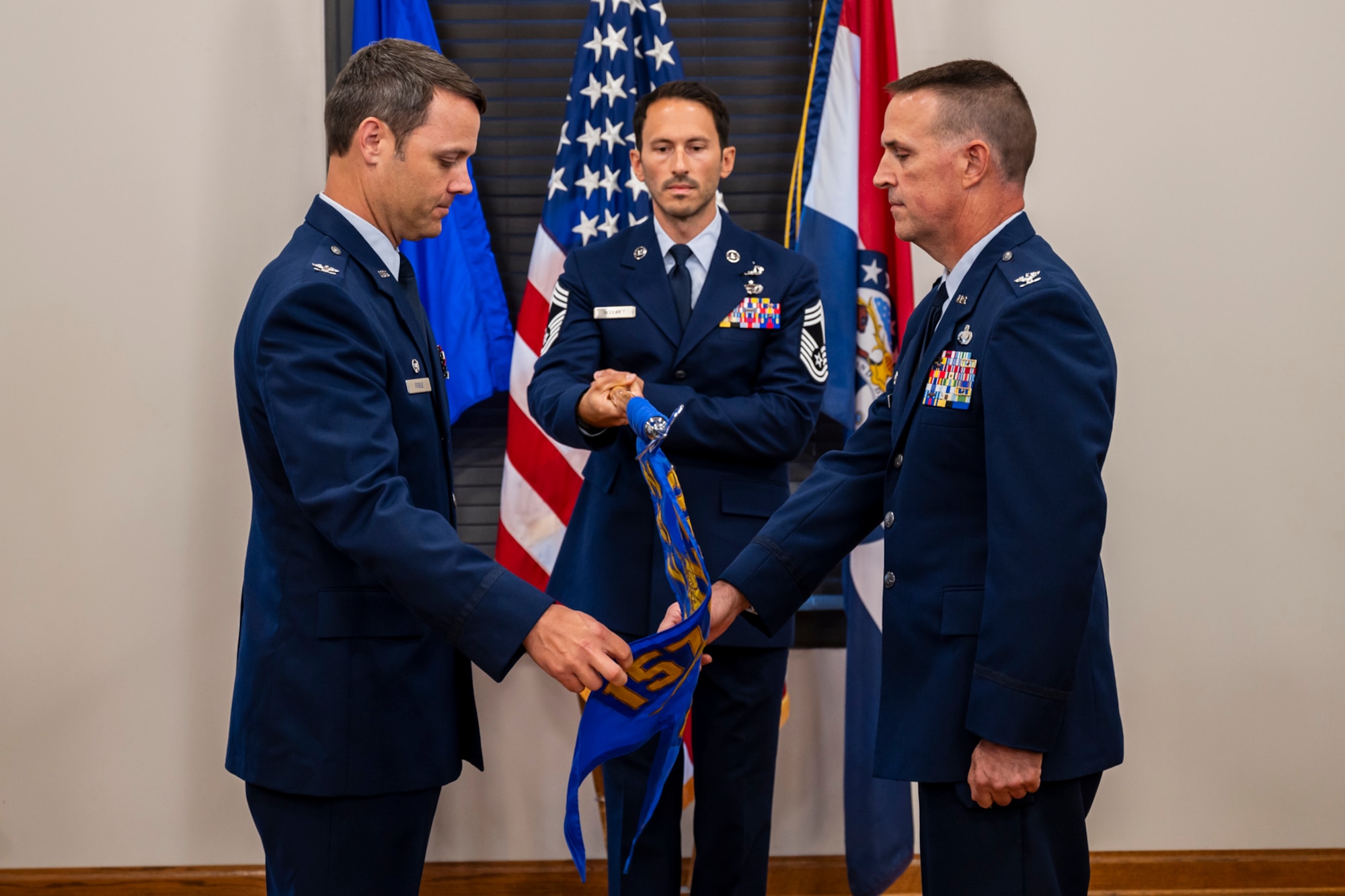 Col. Joshua Fogle, left, commander of the 157th Air Operations Group, and Col. Glen Hawley, right, commander of the 257th Combat Operations Flight, prepare to case the 257th COF guidon during the unit's redesignation ceremony.