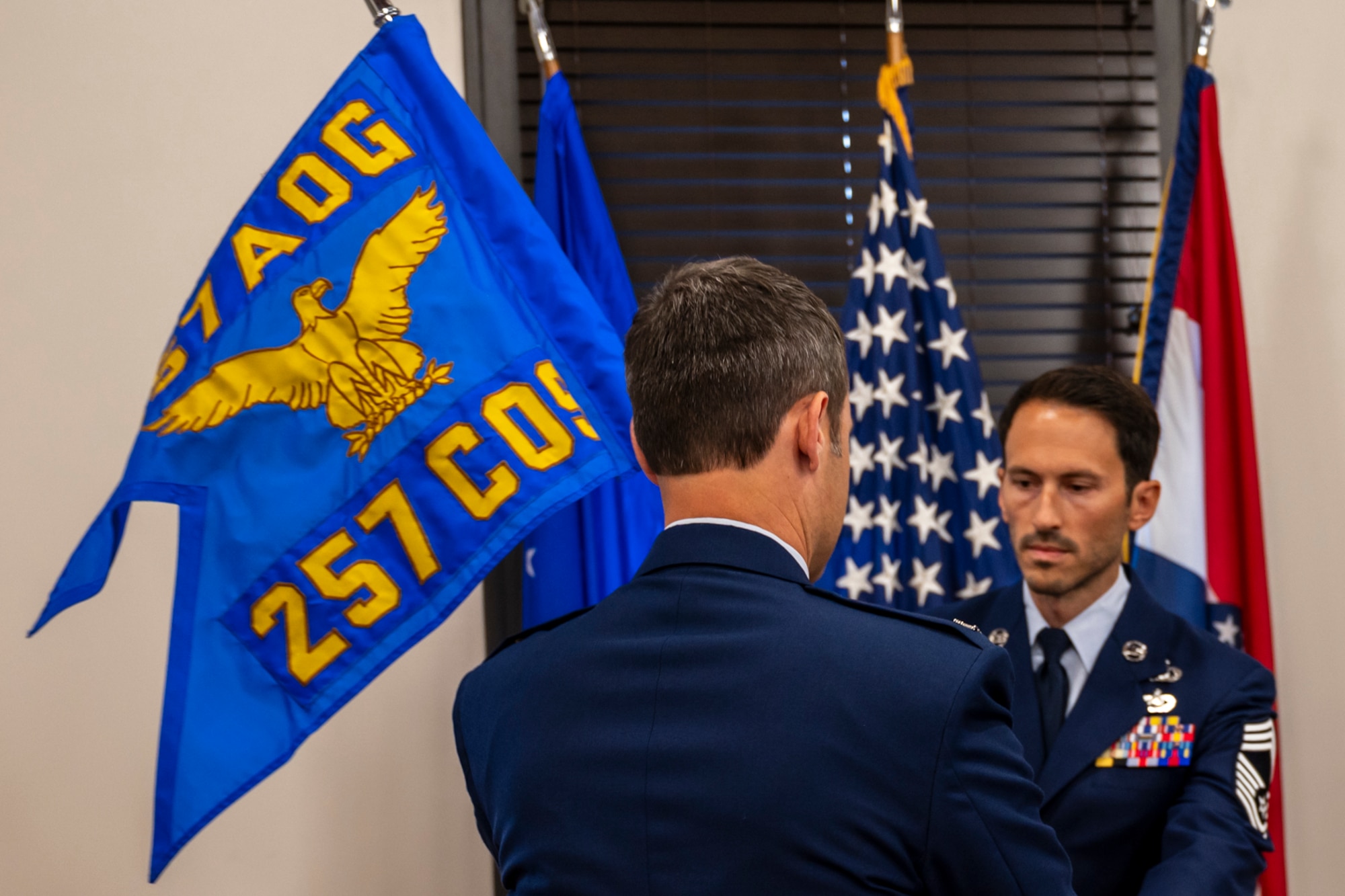 Chief Master Sergeant Nicholas Nodurft passes the newly activated 257th Combat Operations Squadron's guidon to the 157th Air Operations Group commander Col. Joshua Fogle.