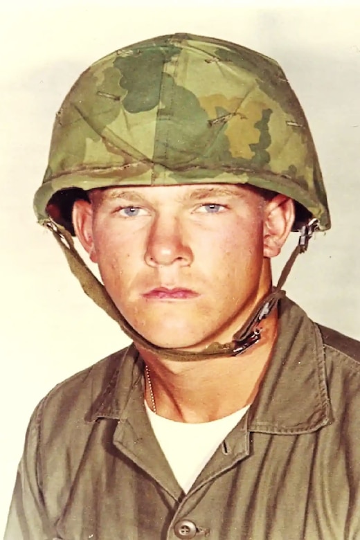 A Marine is pictured in a military uniform and helmet.