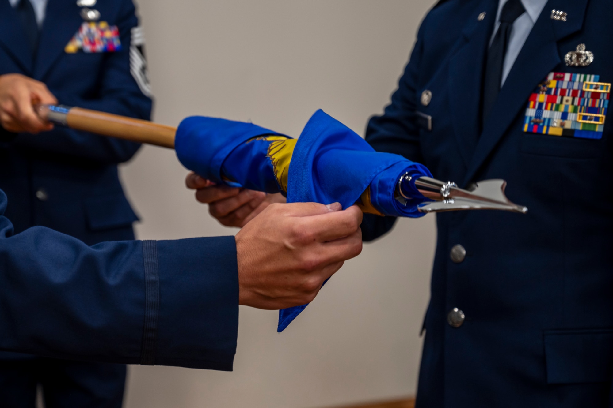 The 257th Combat Operations Flight guidon is prepared for casing during the unit’s redesignation ceremony.