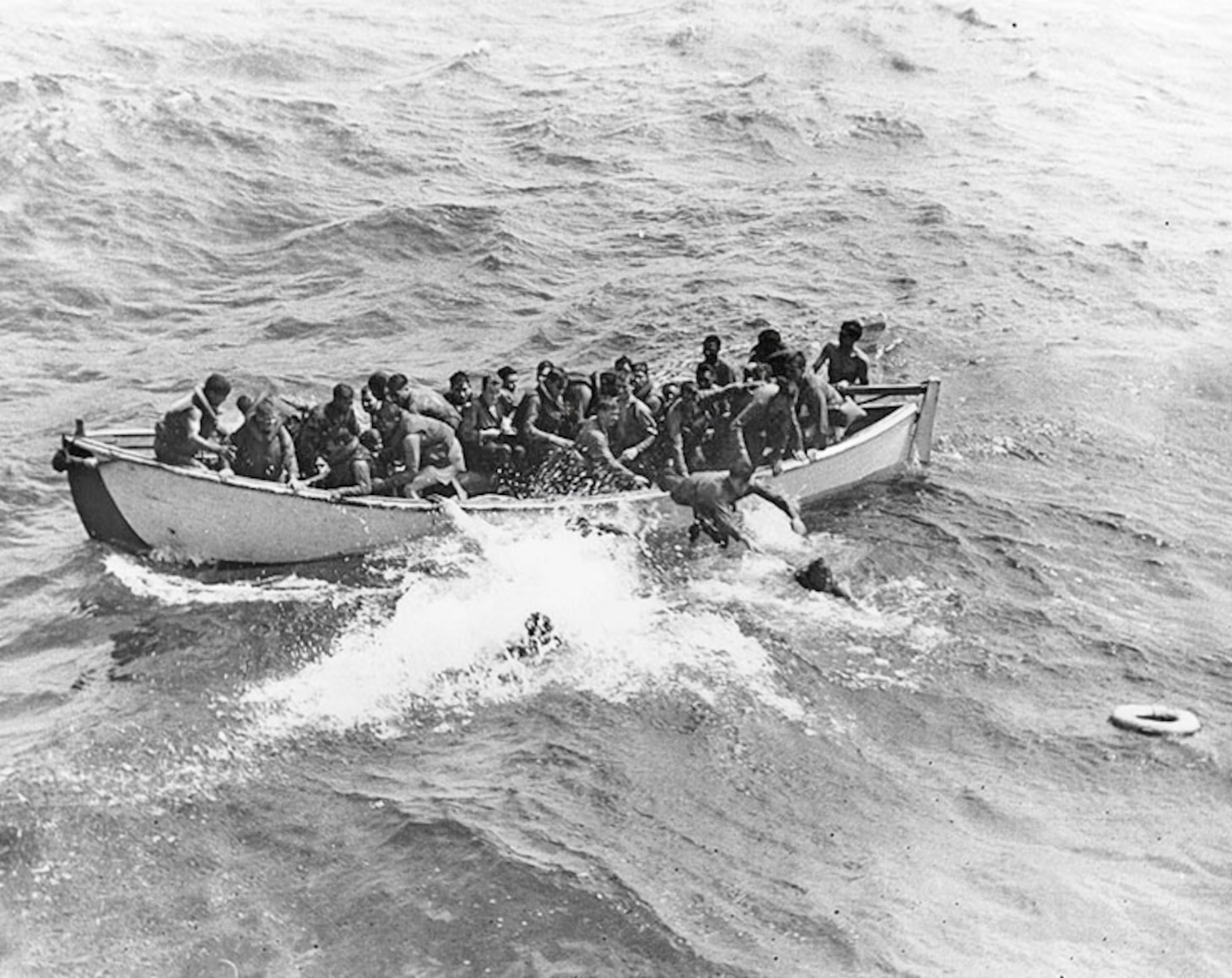 Survivors from the Princeton jam a whaleboat from the destroyer USS Cassin Young (DD 793). The destroyer’s crew had thrown a line over so the survivors could pull themselves closer to the ship as there was always the danger of sharks appearing to threaten men in the water.