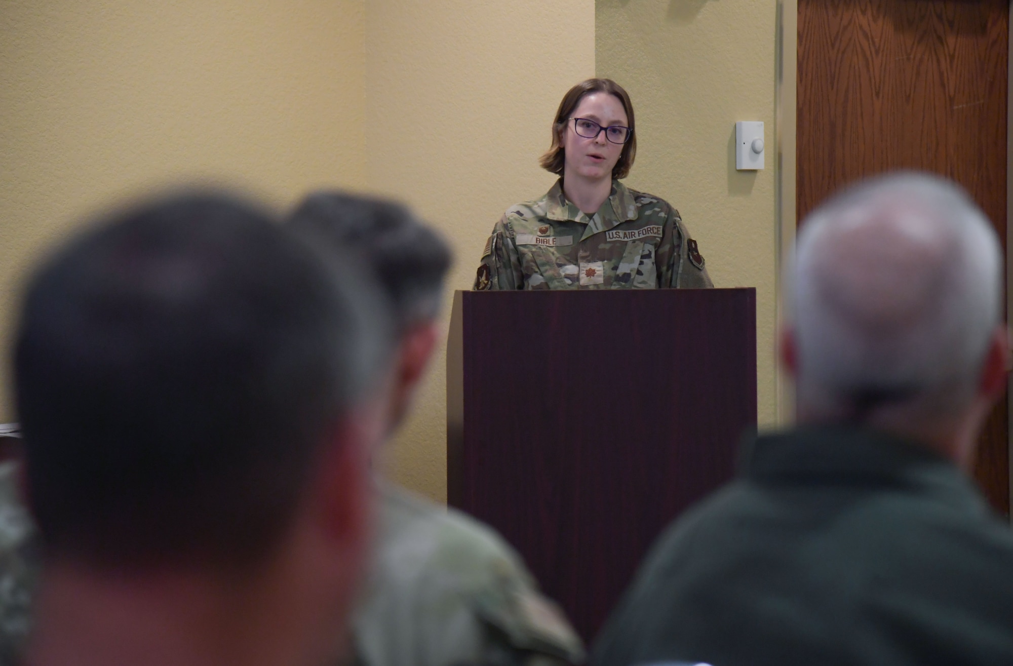 A woman in military uniform speaks from behind a podium