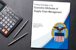 The cover of the white paper appears on a desktop next to a calculator and pens