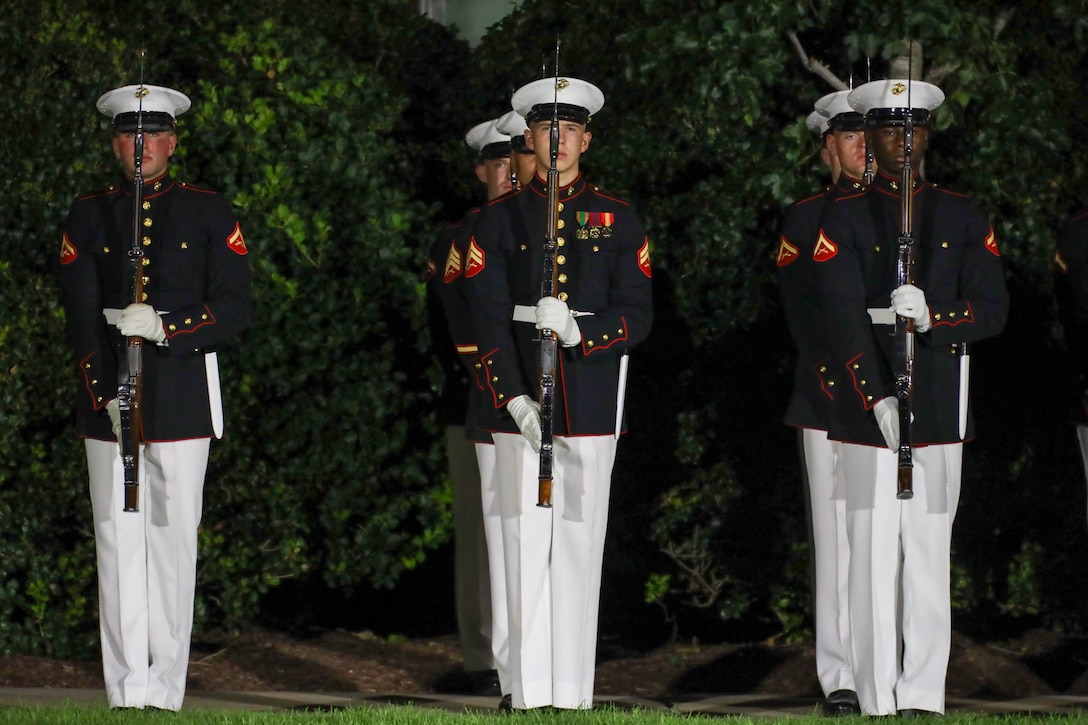 U.S. Marines with the United States Marine Corps Silent Drill Platoon, Alpha Company, Marine Barracks Washington, stand at attention during the final Evening Parade of the 2025 season at Marine Barracks Washington, D.C., Aug. 22, 2025. Lt. Gen. Benjamin Watson, commanding general of Training and Education Command, served as the hosting official, and His Excellency Lord Peter Mandelson, British ambassador to the United States, was the guest of honor. Evening Parades, held every Friday during the summer, feature the U.S. Marine Corps Silent Drill Platoon, “The President’s Own” U.S. Marine Band, “The Commandant’s Own” U.S. Marine Drum and Bugle Corps, and the official Marine Corps Color Guard, showcasing the precision, discipline and 250 years of tradition that define the Corps. (U.S. Marine Corps photo by Cpl. Christopher Prelle)
