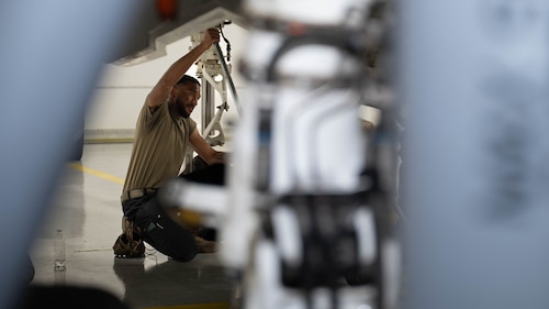 U.S. Air Force Staff Sgt. Hardy Blazian, 95th Fighter Generation Squadron crew chief, secures a load cell beneath an F-35A Lightning II