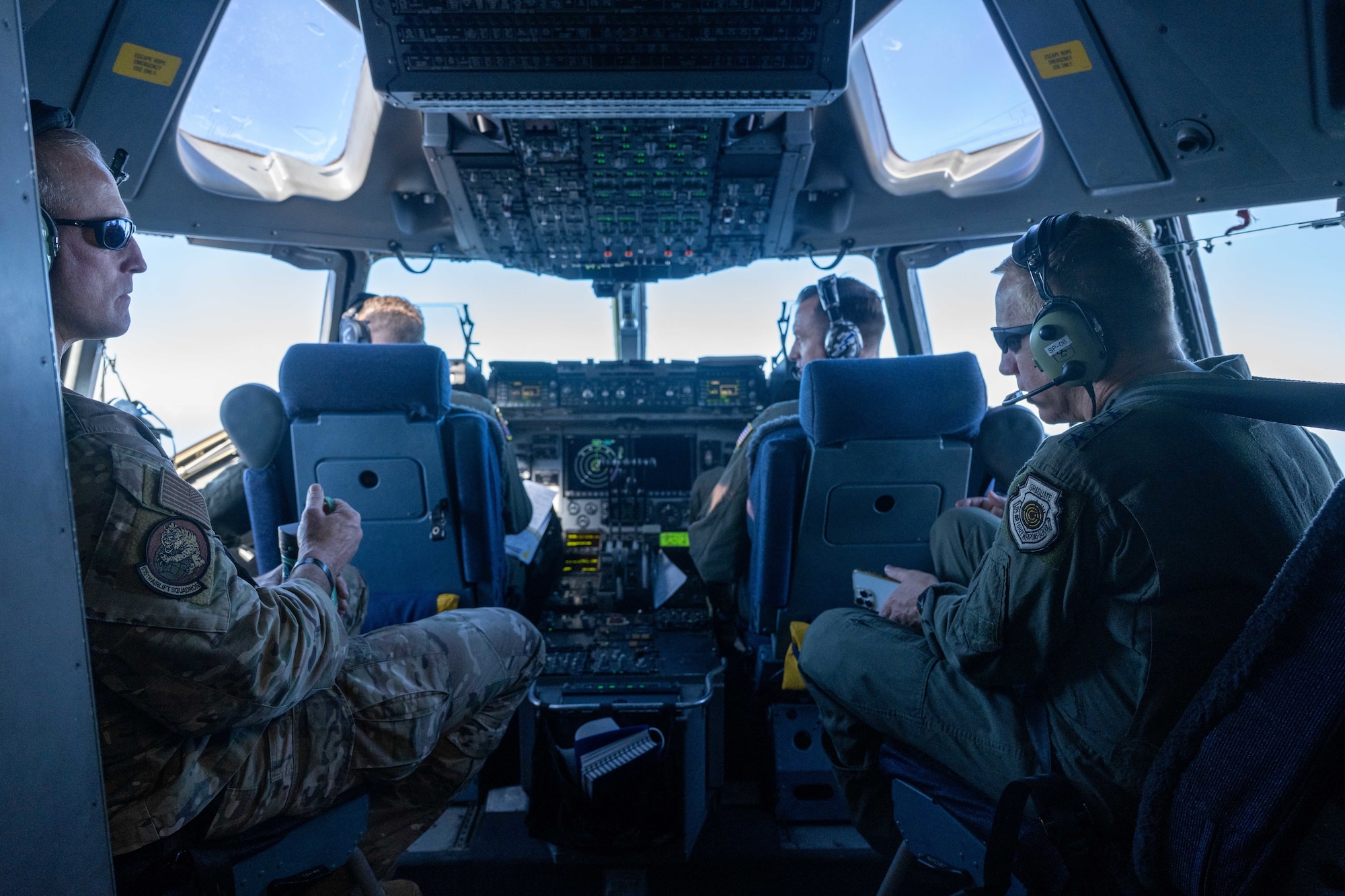 Airmen inside of a flight deck of a C-17.