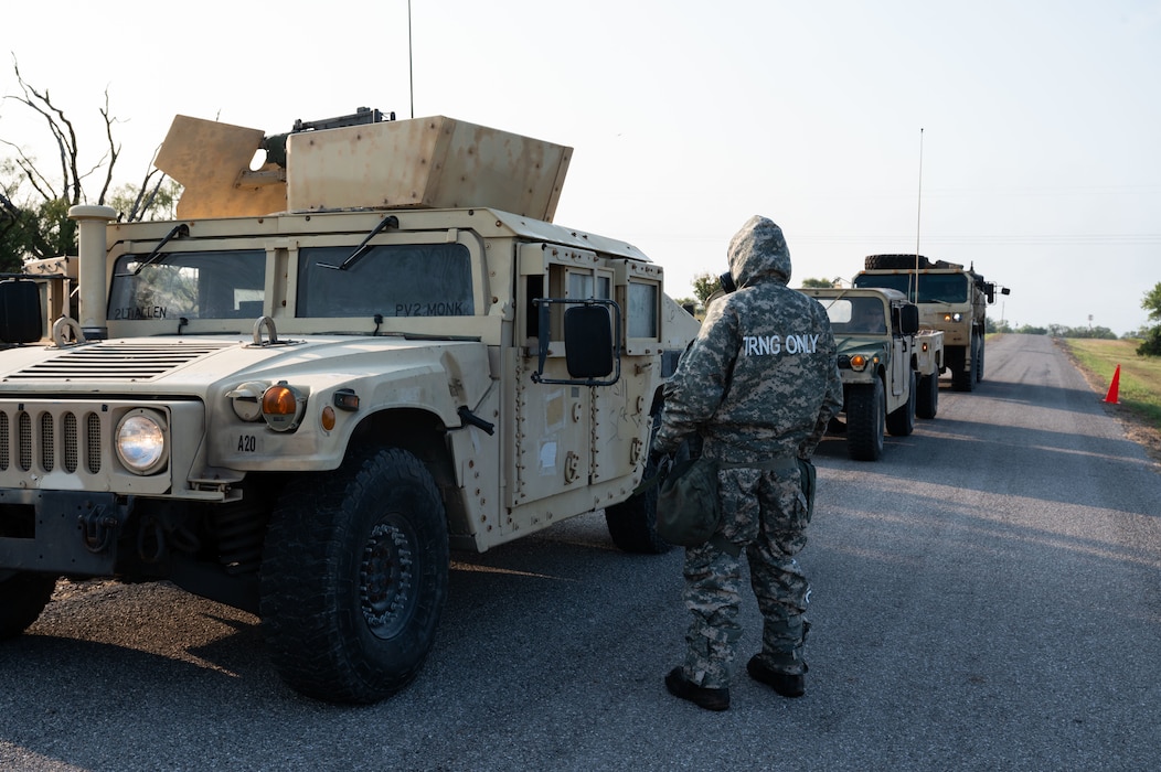 An Airman from Altus Air Force Base’s 97th Civil Engineer Squadron, Readiness and Emergency Management Flight stops a U.S. Army vehicle to explain the decontamination process during an exercise at Fort Sill, Oklahoma, September 7, 2025. During the exercise, Soldiers from the 3-2 Air Defense Artillery Battalion simulated exposure to an unknown Chemical, Biological, Radiological, and Nuclear agent. This forced them to rapidly break down their camp and move all personnel and equipment through a decontamination line before establishing a new position. (U.S. Air Force photo by Tech. Sgt. Hailey Haux)