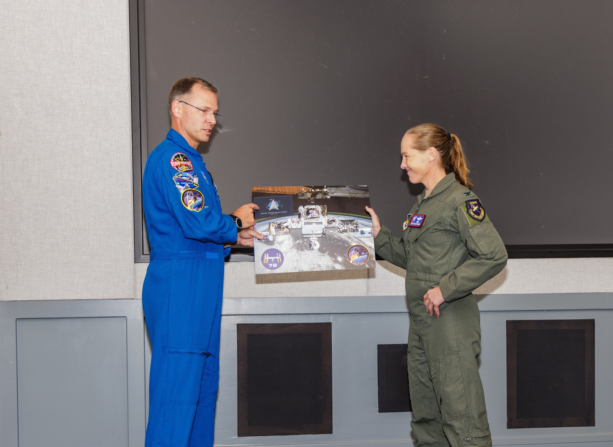 Space Force Guardian and NASA Astronaut Brig. Gen. Nick Hague presents a Space Force flag to the U.S. Test Pilot School commandant, Col. Maryann Karlen, that was flown aboard Crew-9 Dragon Freedom and the International Space Station Expedition 71/72 during a 171-day journey traveling over 72 million miles. (Photo Lindsey Iniguez)