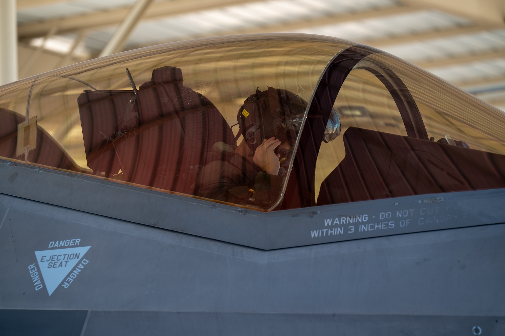 U.S. Air Force Capt. Nathaniel Jewell, 61st Fighter Squadron fighter pilot, adjusts his helmet and oxygen mask inside an F-35A Lightning II before takeoff, Sept. 10, 2025, at Luke Air Force Base, Arizona. Instructor Pilot War Day focuses on advanced air-to-air defensive maneuvers, helping to shape the world’s greatest fighter pilots and combat-ready Airmen. (U.S. Air Force Photo by Airman Rebecca Wagner)