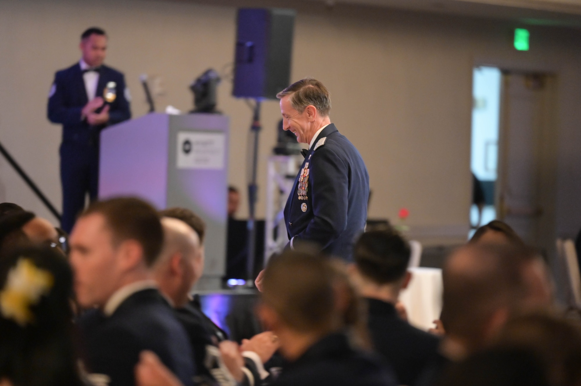 An Airman walks through a crowd during a ceremony.