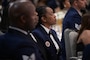 Airmen sit in attendance during a ceremony.