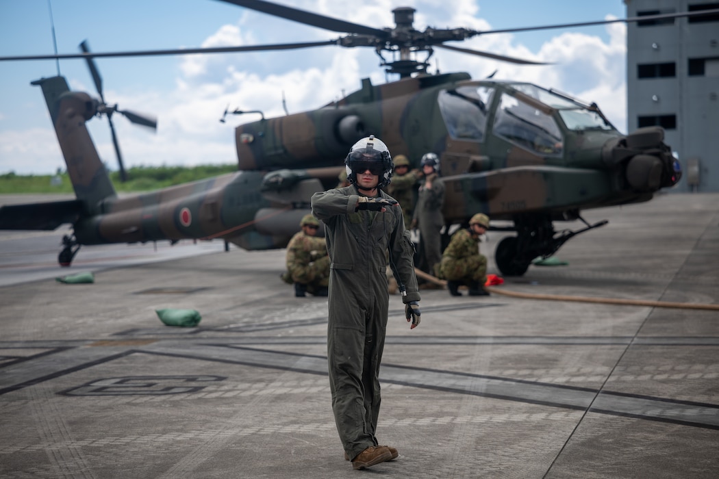 U.S. Marine Corps Cpl. Cole Goodrich, a crew chief with Marine Medium Tiltrotor Squadron 262, Marine Aircraft Group 36, 1st Marine Aircraft Wing, gives a signal for refueling during exercise Resolute Dragon 25 on Ie Shima, Japan, Sept. 19, 2025.