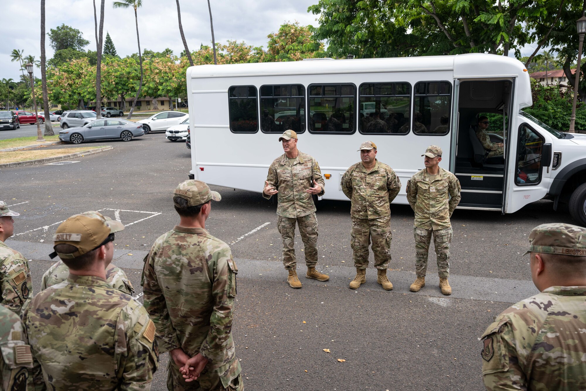 Airmen stand outside of a surrey in a group.
