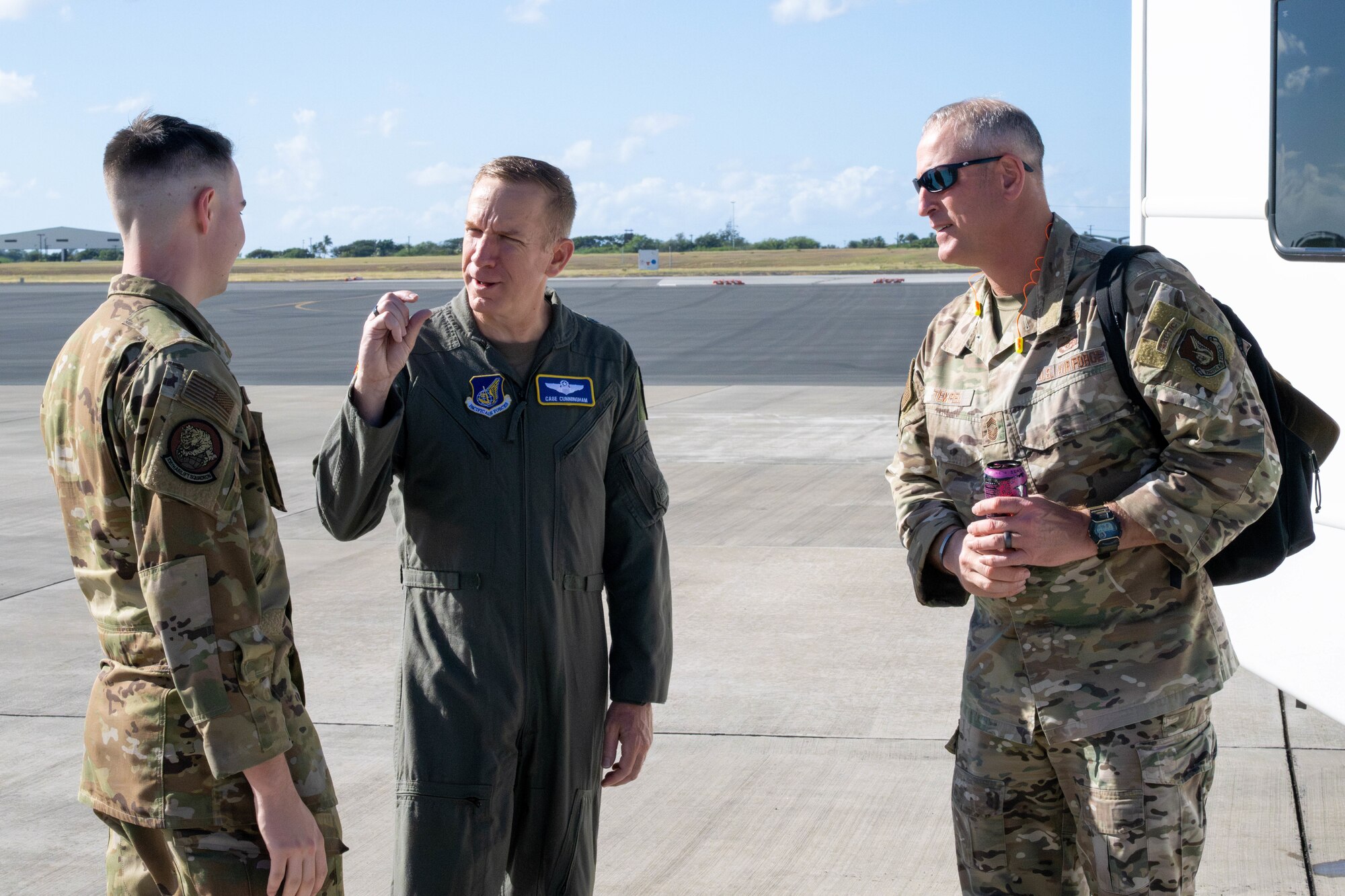 Three Airmen speaking outside of a surrey.
