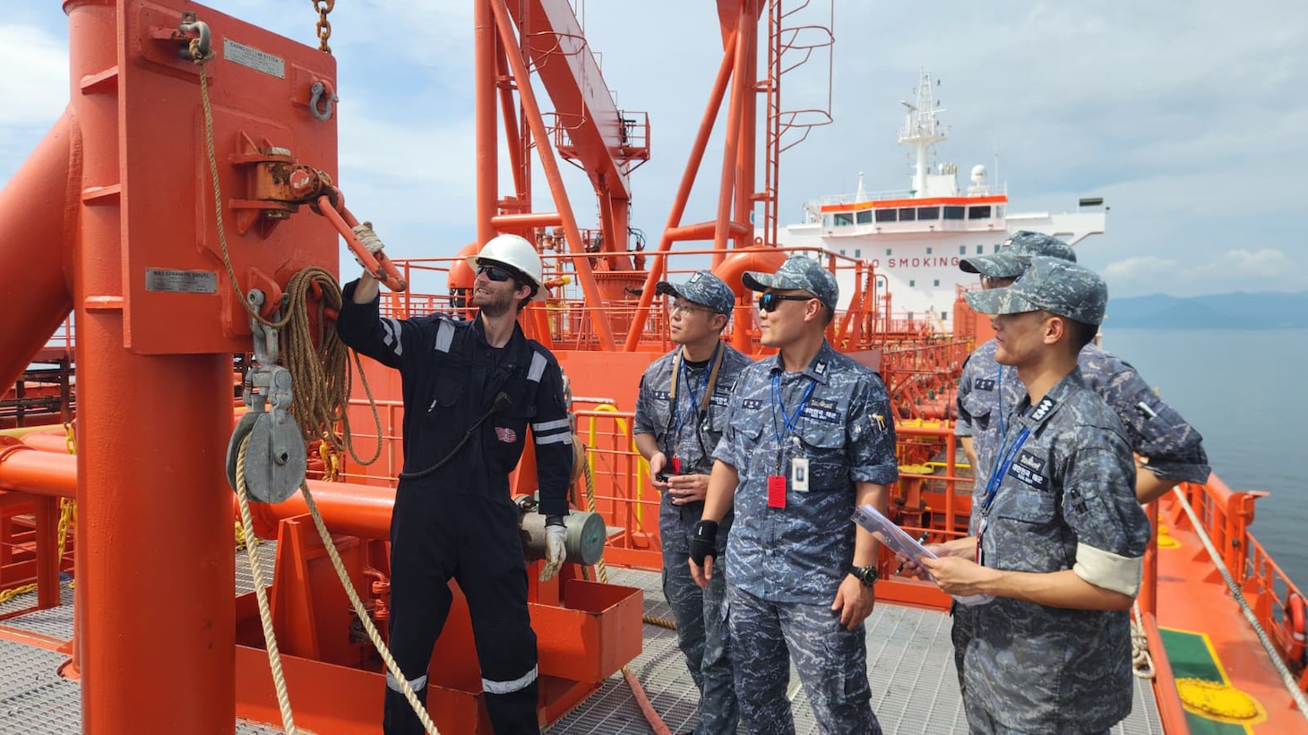 Contracted mariner Mark Harper, left, cargo mate, motor tanker Allied Pacific, shows Republic of Korea (ROK) crew members of ROK Cheonji-class fast combat support ship ROKS Daecheong (AOE-58) the consolidated cargo replenishment (CONSOL) station and describes the process for connecting the span wire/ROBB coupling, during familiarization training, at Chinhae, Sept. 15.