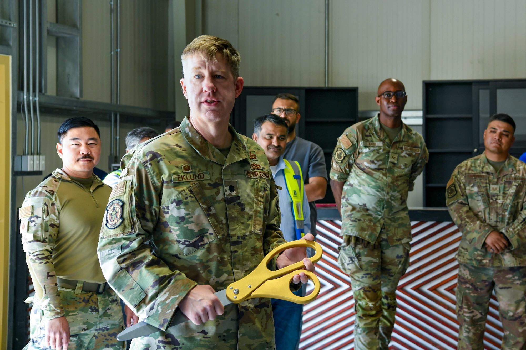 Airman holds a pair of ribbon cutting scissors