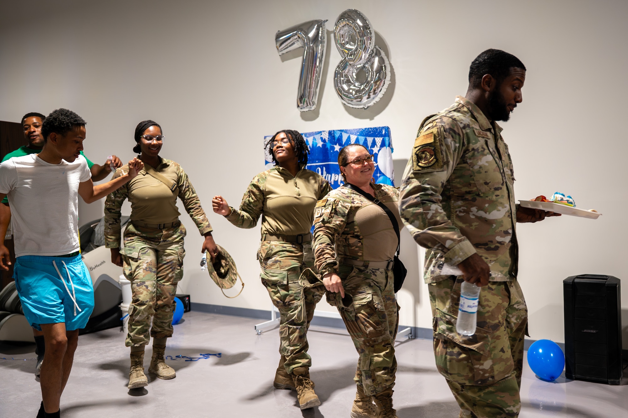 4 Airmen dance in front of a 78 balloon