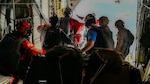 Guardian Angel team members from the 129th Rescue Wing, California Air National Guard, prepare to jump from an HC-130J Combat King II during a long-range maritime rescue mission approximately 885 nautical miles off the California coast. The team parachuted with medical equipment to reach the Panamanian-flagged cargo vessel Grand Vega and stabilize a Filipino mariner suffering stroke-like symptoms.