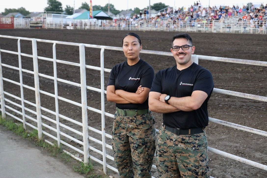 U.S. Marine Corps Staff Sgt. Jesus Delatorre, right, and Sgt. Valencia Begay, left, recruiters with Recruiting Station Kansas City, 9th Marine Corps District, pose for a photo during the Johnson County Fair, Kansas City, Missouri, July 31, 2025. Johnson County has celebrated the agricultural heritage of the community since 1939. (U.S. Marine Corps photo by Sgt. Alexis Moradian)