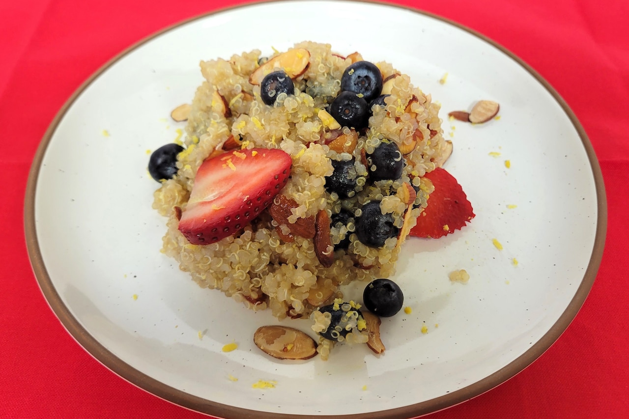 A mound of quinoa and berries sits on a plate.