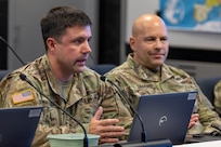 Sgt. 1st Class Jonathan Suggs, 45th Finance Center Team B noncommissioned officer in charge from Fort Shafter Hawaii, makes remarks as Maj. Frank Simmons, 45th FC Team C officer in charge listens on during a staff exercise in the Mark Sullivan Auditorium at the Maj. Gen. Emmett J. Bean Federal Center in Indianapolis Sept. 18, 2025. The four-day exercise brought together elements from the 45th FC’s headquarters and three geographically separated teams to assess the unit’s operational capacity and limitations while enhancing its future operational reach for large scale and multidomain operations. (U.S. Army photo by Mark R. W. Orders-Woempner)