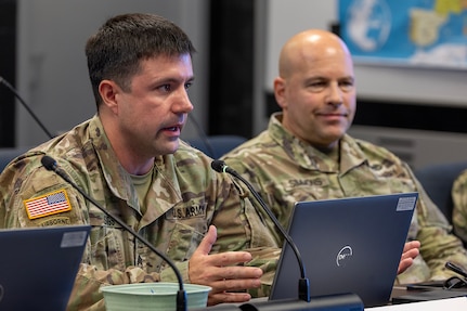 Sgt. 1st Class Jonathan Suggs, 45th Finance Center Team B noncommissioned officer in charge from Fort Shafter Hawaii, makes remarks as Maj. Frank Simmons, 45th FC Team C officer in charge listens on during a staff exercise in the Mark Sullivan Auditorium at the Maj. Gen. Emmett J. Bean Federal Center in Indianapolis Sept. 18, 2025. The four-day exercise brought together elements from the 45th FC’s headquarters and three geographically separated teams to assess the unit’s operational capacity and limitations while enhancing its future operational reach for large scale and multidomain operations. (U.S. Army photo by Mark R. W. Orders-Woempner)