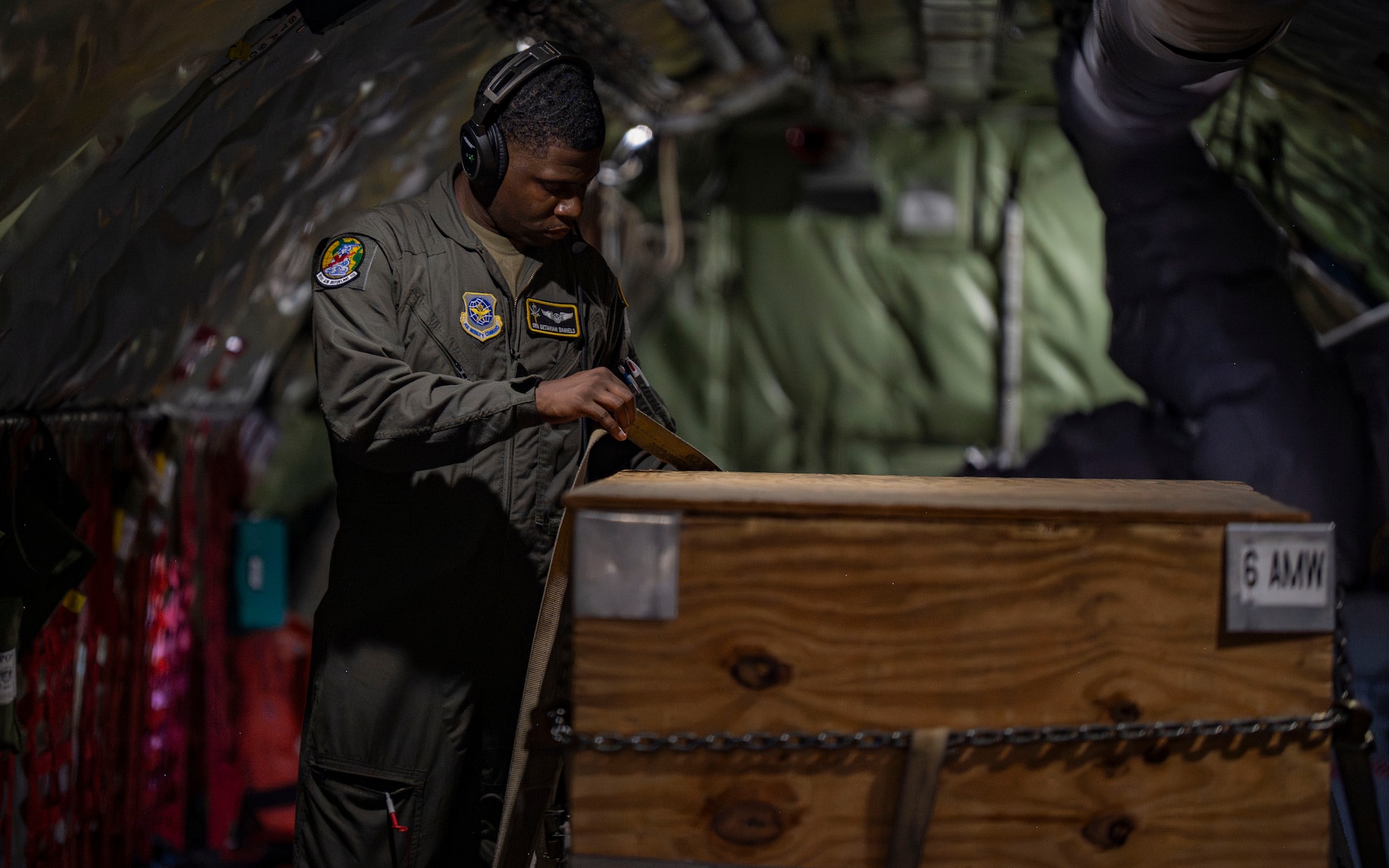U.S. Air Force Senior Airman Detavian Daniels, a 91st Air Refueling Squadron boom operator, secures cargo on a KC-135 Stratotanker aircraft, assigned to the 6th Air Refueling Wing, at MacDill Air Force Base, Florida, Sept. 18, 2025. When not performing in-flight refueling, boom operators are responsible for assisting pilots and passengers, as well as storing and securing cargo. (U.S. Air Force photo by Airman 1st Class Monique Stober)