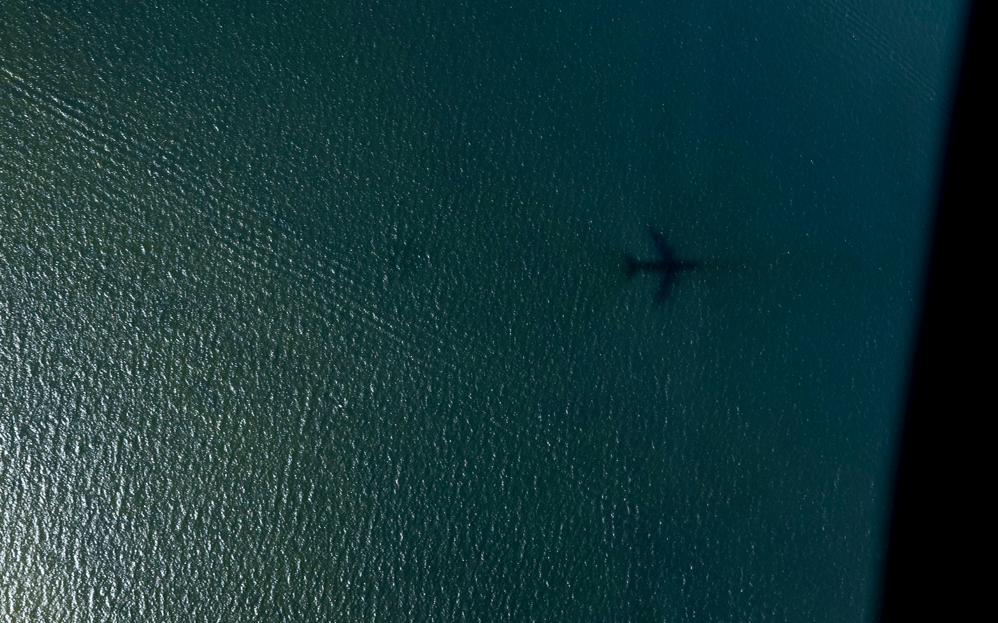 The shadow of a KC-135 Stratotanker aircraft, assigned to the 6th Air Refueling Wing, is shown over Tampa Bay, Florida, Sept. 18, 2025. The KC-135 provides a key capability in Air Mobility Command’s global reach mission, and has excelled in this role for more than 60 years. (U.S. Air Force photo by Airman 1st Class Monique Stober)