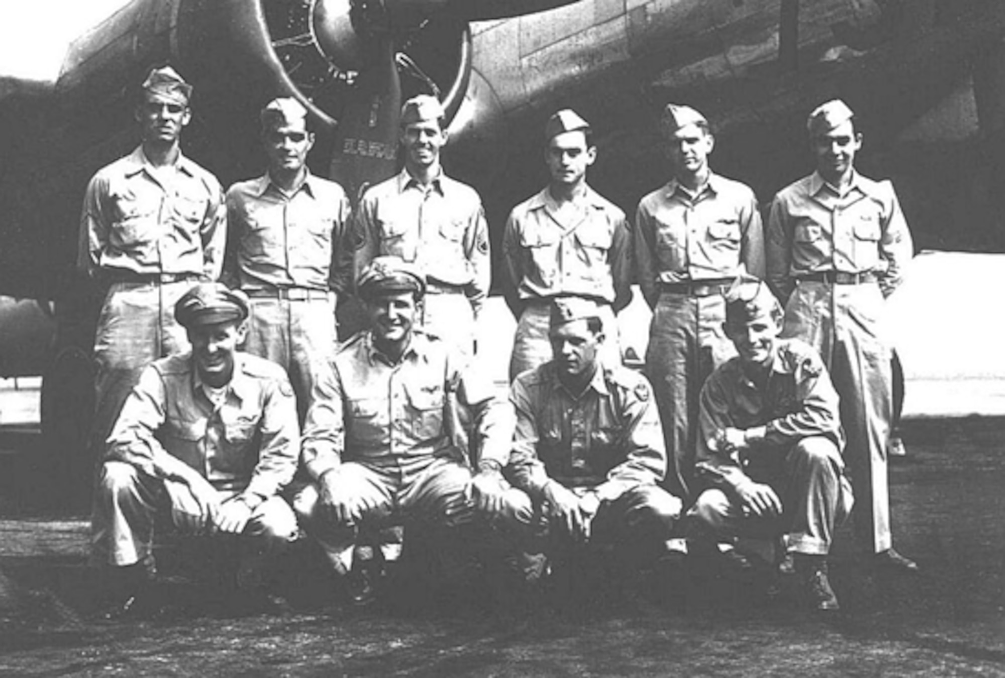 An aircrew poses in front of an aircraft.