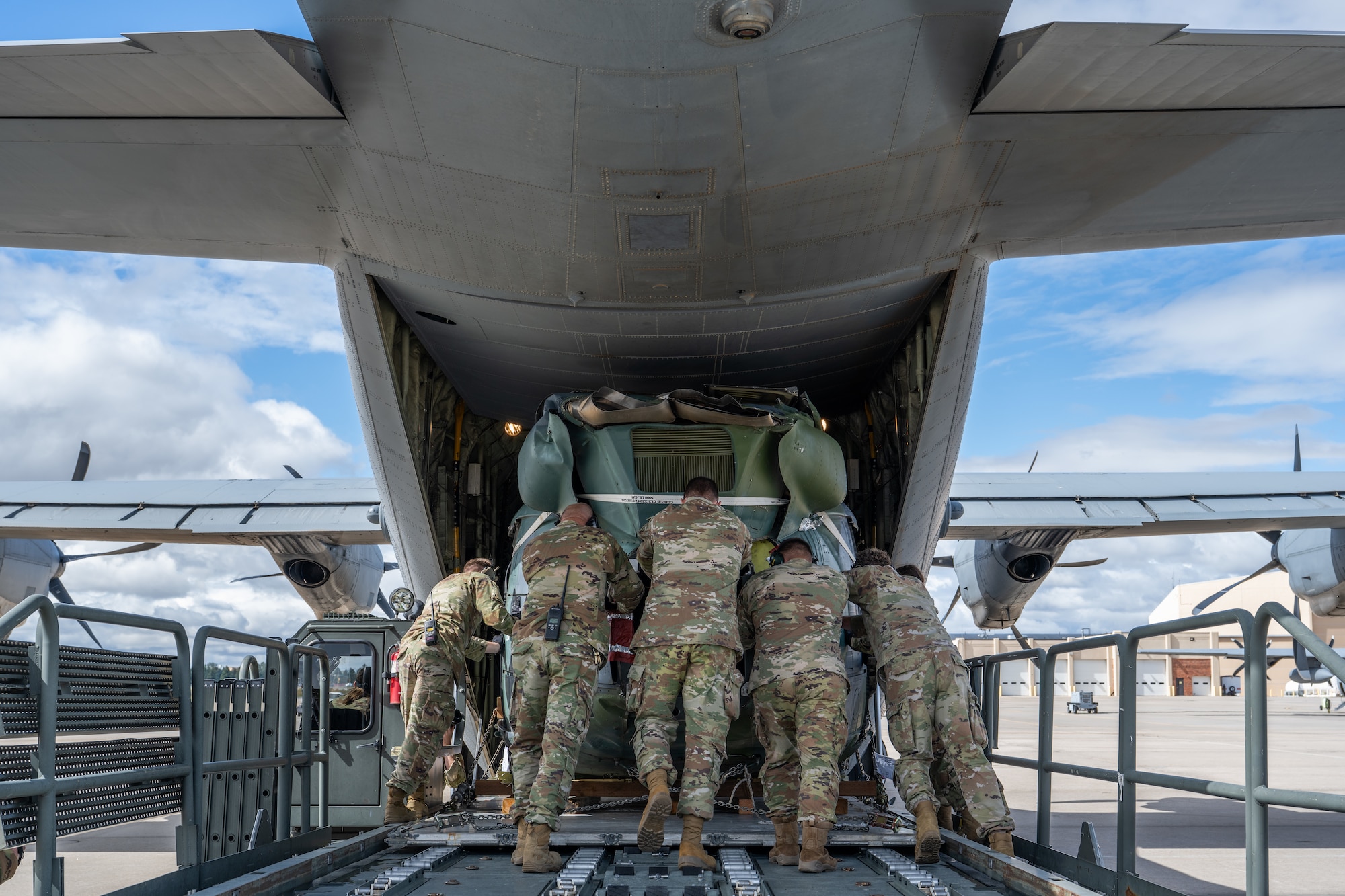 U.S. Air Force Airmen assigned to the 317th Airlift Wing and 153rd AW work together to load a UH-1 helicopter onto a C-130J Super Hercules at Wyoming Air National Guard Base in Cheyenne, Wyo., Sept. 17, 2025. The 317th AW transported the helicopter to the 436th Training Squadron’s crash lab at Dyess Air Force Base, Texas, where it will be used for realistic aircraft mishap response and recovery training. (U.S. Air Force photo by Airman 1st Class Caleb Schellenberg)