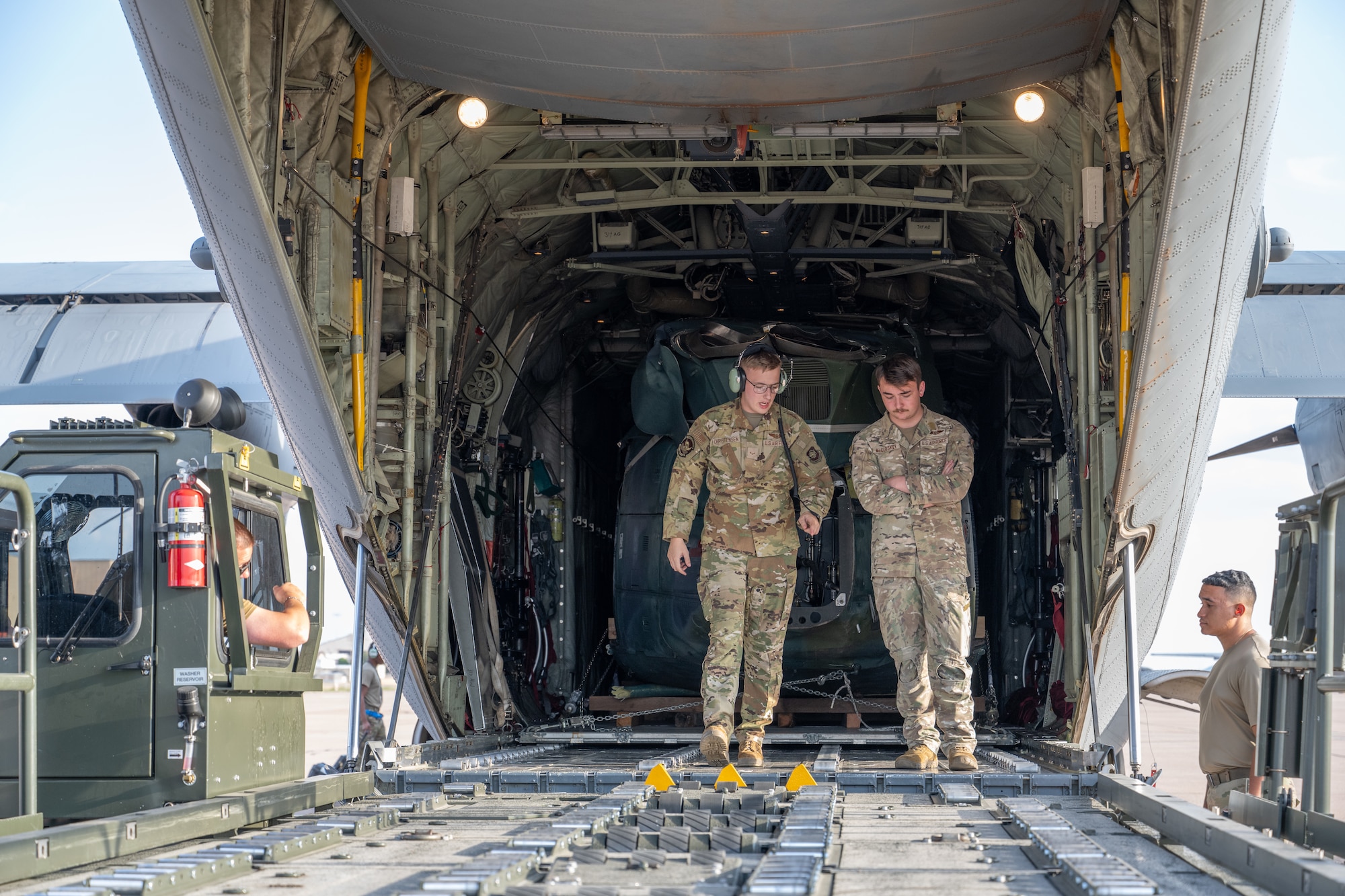 U.S. Air Force Senior Airman Cory McCloskey and Airman 1st Class Bruce Christensen, both 39th Airlift Squadron loadmasters, prepare to offload a UH-1 helicopter from a C-130J Super Hercules at Dyess Air Force Base, Texas, Sept. 17, 2025. The 317th Airlift Wing transported the helicopter from Wyoming Air National Guard Base to Dyess where it will be used as a training aid for the 436th Training Squadron. (U.S. Air Force photo by Airman 1st Class Caleb Schellenberg)