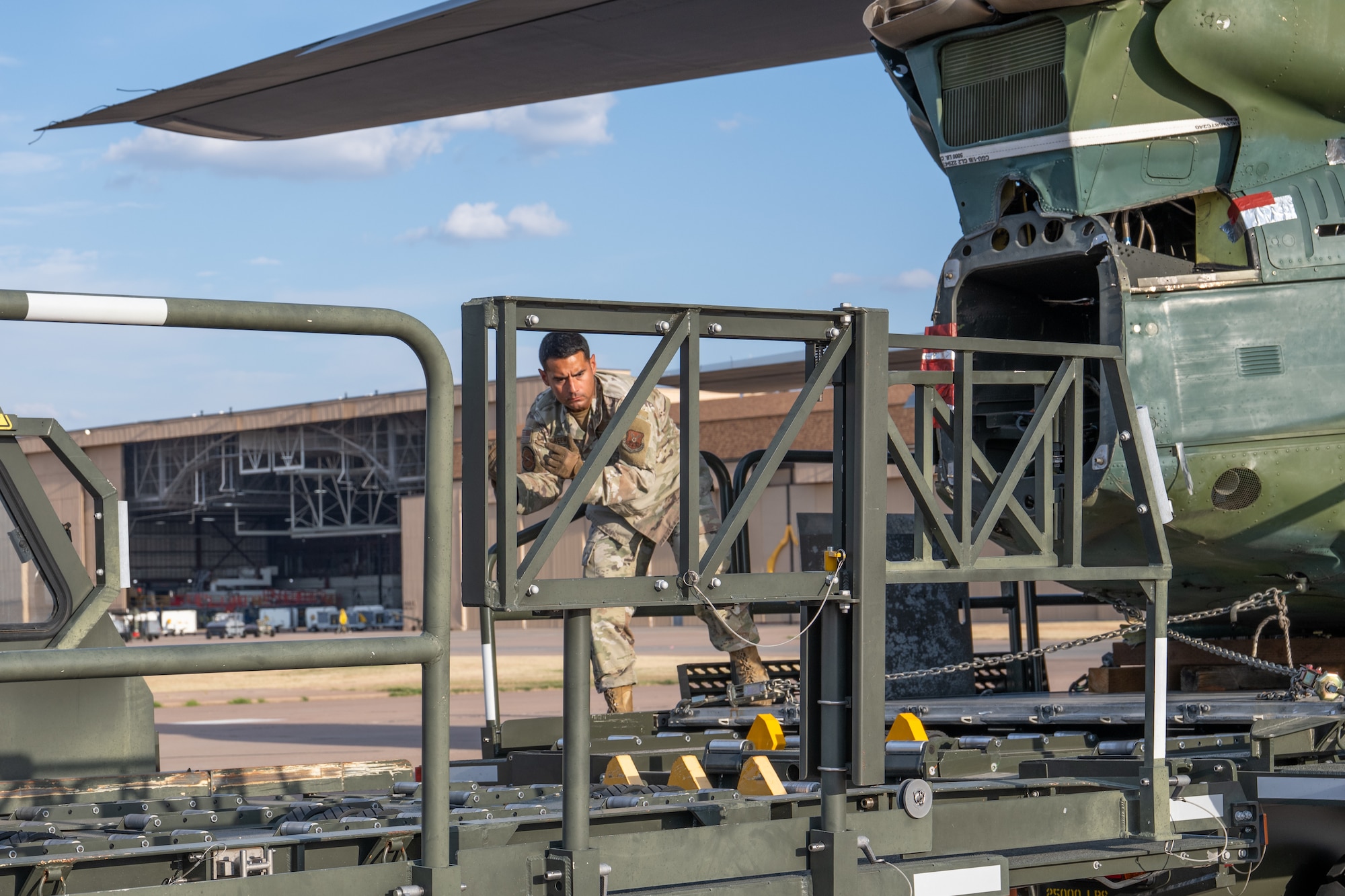 U.S. Air Force Master Sgt. Joshua Greenbaum, 7th Logistics Readiness Squadron air terminal function superintendent, offloads a UH-1 helicopter from a C-130J Super Hercules at Dyess Air Force Base, Texas, Sept. 17, 2025. The 317th Airlift Wing transported the helicopter back to Dyess to support the 436th Training Squadron’s aircraft mishap response and recovery training. (U.S. Air Force photo by Airman 1st Class Caleb Schellenberg)