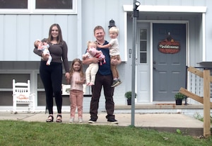 Senior Airman Harrison Friar, 97th Intelligence Squadron airborne linguist, and his wife Brielle, pose in front of their home Sept. 18, 2025. Friar defended his family and neighbors when an active shooter attacked the neighborhood on Aug. 6, 2025. He returned fire hitting the perpetrator twice, which caused him to retreat. (U.S. Air Force photo by Dana Heard)