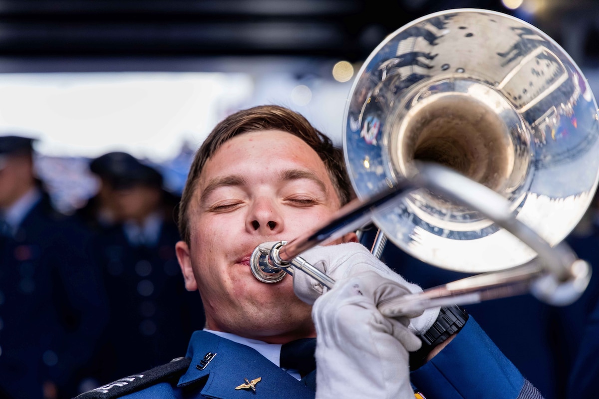 A close-up of a U.S. Air Force Academy cadet in ceremonial dress playing a trombone.