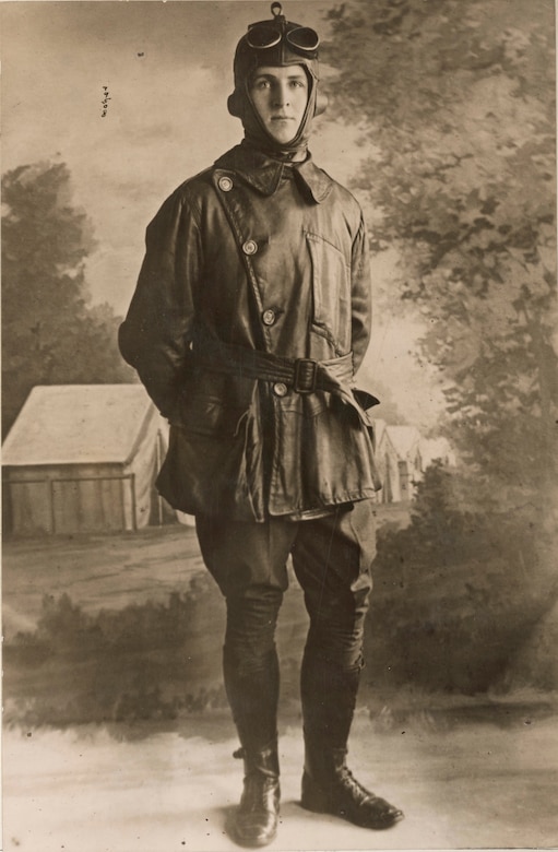 A man in a World War I-era flight suit poses for a photo.