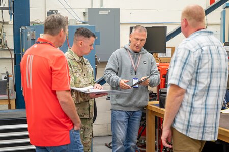 Photo of Lt. Col. Brooks talking with 3 Tobyhanna employees