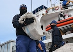 A Coast Guard Cutter Diligence (WMEC 616) crew member carries a bundle of illicit narcotics off the cutter during a drug offload at Coast Guard Sector St. Petersburg, Florida, Sept. 22, 2025. Diligence’s crew conducted a 57-day patrol in the Caribbean Sea to counter illicit drug smuggling in the region. (U.S. Coast Guard photo by Petty Officer 1st Class Riley Perkofski)