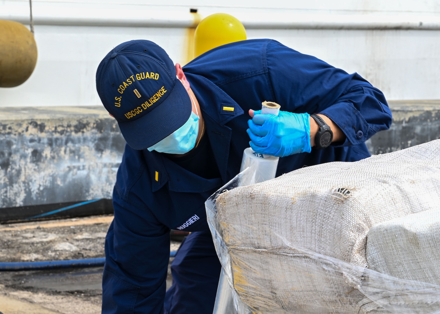 A Coast Guard crew member assigned to Coast Guard Cutter Diligence (WMEC 616) wraps bails of illicit narcotics during a drug offload at Coast Guard Sector St. Petersburg, Florida, Sept. 22, 2025. Diligence deployed in support of Joint Interagency Task Force - South to the Coast Guard District Southeast area of responsibility, where crew members interdicted more than 10,000 pounds of illicit narcotics. (U.S. Coast Guard photo by Petty Officer 1st Class Riley Perkofski)