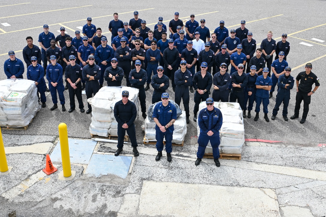 The crew of Coast Guard Cutter Diligence (WMEC 616) poses for a group photo during a drug offload at Coast Guard Sector St. Petersburg, Florida, Sept. 22, 2025. Diligence’s crew offloaded nearly $65 million in illicit narcotics interdicted in the Western Caribbean Sea. (U.S. Coast Guard photo by Petty Officer 1st Class Riley Perkofski)