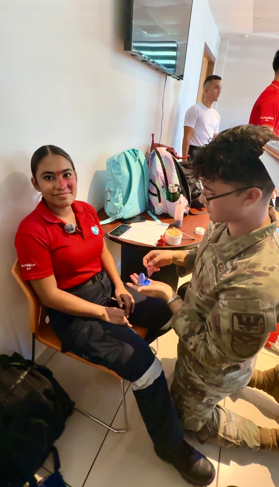 A student receives make up to look like wounds in preparation for pretending to be a patient during a mass casualty training scenario.