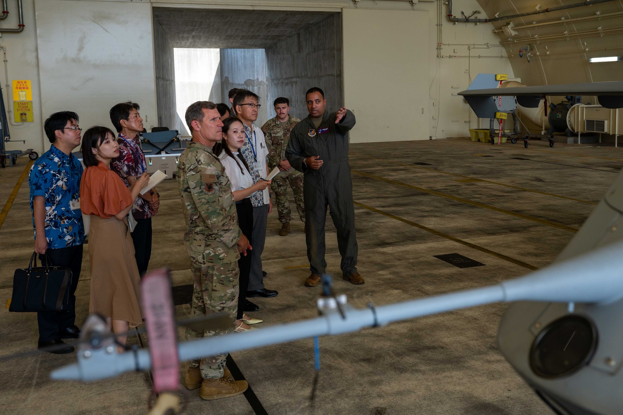 U.S. Air Force Lt. Col. Christopher Saltares, right, 319th Expeditionary Reconnaissance Squadron commander, briefs Mr. Masaru Murai, Okinawa Defense Bureau director general, on MQ-9 Reaper capabilities during a familiarization tour at Kadena Air Base, Sept. 11, 2025.
