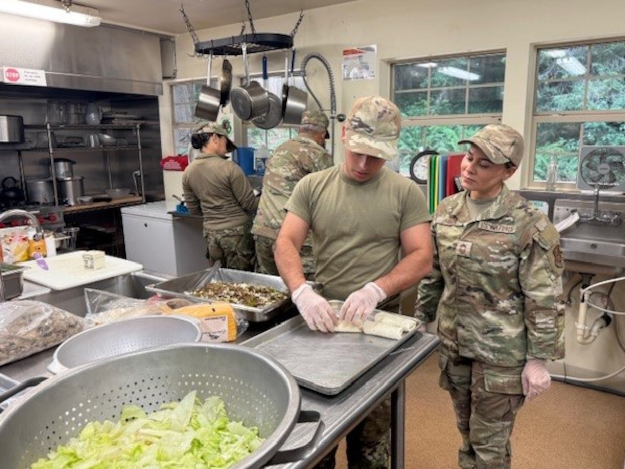 U.S. Airmen with the 156th Force Support Squadron, Puerto Rico Air National Guard, prepare meals during an Innovative Readiness Training project at Redwoods National Park, California, June 2025. IRT delivers joint training opportunities to increase deployment readiness and provides key services to American communities. (U.S. Air National Guard courtesy photo)