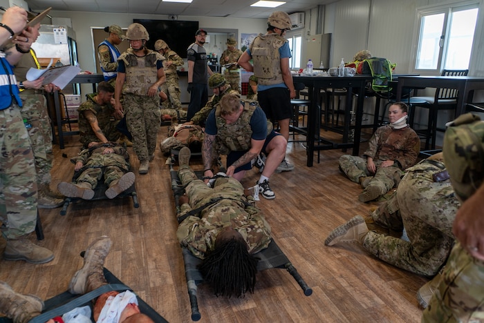 The frame is filled with a collection of casualties and medics in battle rattle