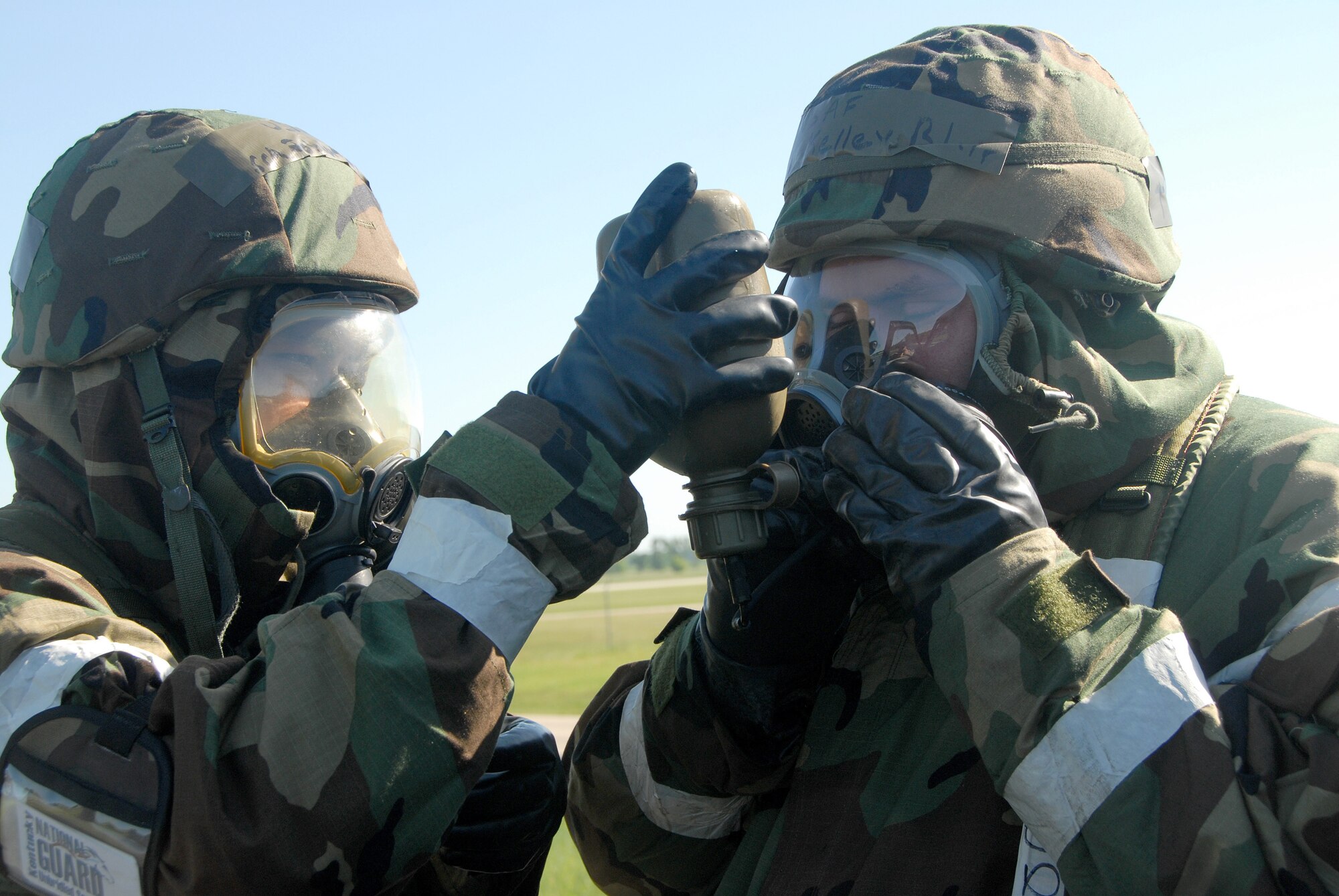 An Airman from the Kentucky Air National Guard’s 123rd Airlift Wing helps his buddy drink from a canteen during a simulated chemical attack at Volk Field, Wis., June 21, 2009. The event was part of an Operational Readiness Exercise designed to test the wing’s ability to support homeland defense operations. (U.S. Air National Guard photos by Tech. Sgt. Dennis Flora)