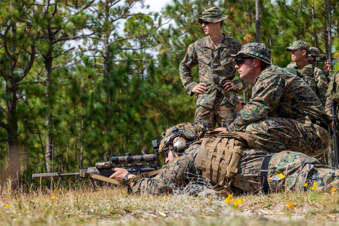 U.S. Marine Corps Sgt. James Ditmar, a rifleman with Golf Company, 2nd Battalion, 2nd Marine Regiment, demonstrates the stances for a live course of fire for participating multinational forces during a multinational marksmanship range as part of exercise UNITAS 2025 at Marine Corps Base Camp Lejeune, North Carolina, Sept. 23, 2025. UNITAS, which is Latin for “unity,” was conceived in 1959 and has taken place annually since first conducted in 1960. This marks the 66th iteration of the world’s longest running annual multinational maritime exercise. (U.S. Marine Corps photo by Lance Cpl. Jack Labrador)